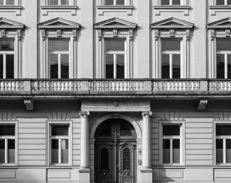 Historisches Gebäude mit Fenstern und Balkon im neoklassizistischen Stil.